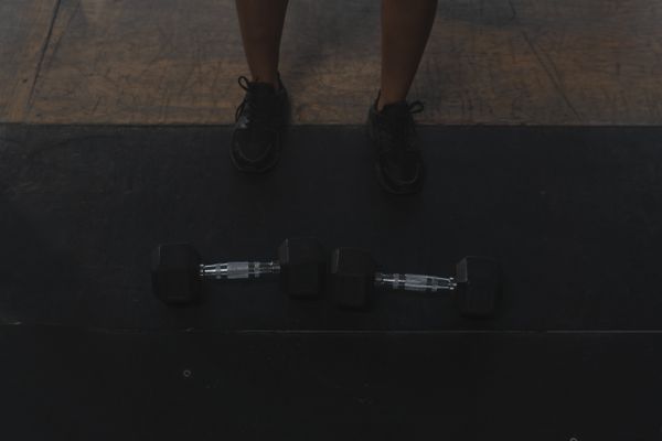 Person standing between dumbbells ready for workout