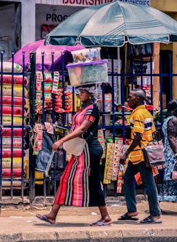 Street scene of vendors in vibrant Benin City market, showcasing daily commerce activities.