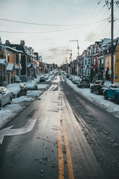 Asphalt road between dwelling houses in winter town