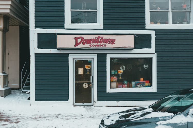 Book Shop Facade Against Modern Car In Winter City