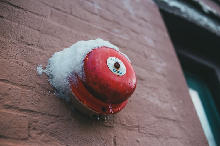 Fire Alarm Button On Brick Wall Of Building In Winter