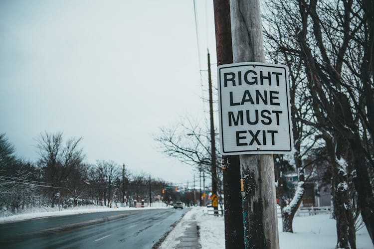 Road Sign With Inscription On Post In Winter Town