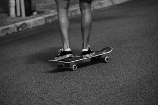 Monochrome image of a skateboarder riding casually, showcasing skate culture.