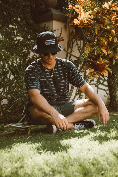 A Man Sitting on His Skateboard