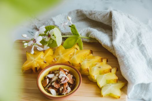 Carambola Fruit and Nuts in a Bowl on a Cutting Board 
