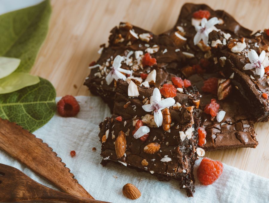 Chocolate brownies topped with raspberries, nuts and edible flowers