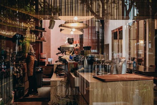 A barista working in a cozy, modern cafe with stylish lighting and decor.