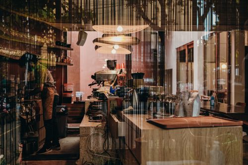 Free A barista working in a cozy, modern cafe with stylish lighting and decor. Stock Photo