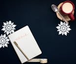 平面图像以咖啡杯、笔记本和雪花为背景，营造出舒适的冬季氛围