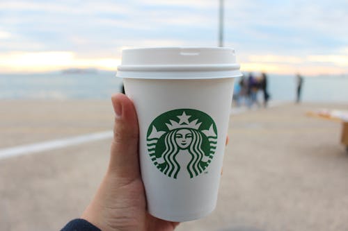 Person Holding Star Buck Plastic Cup