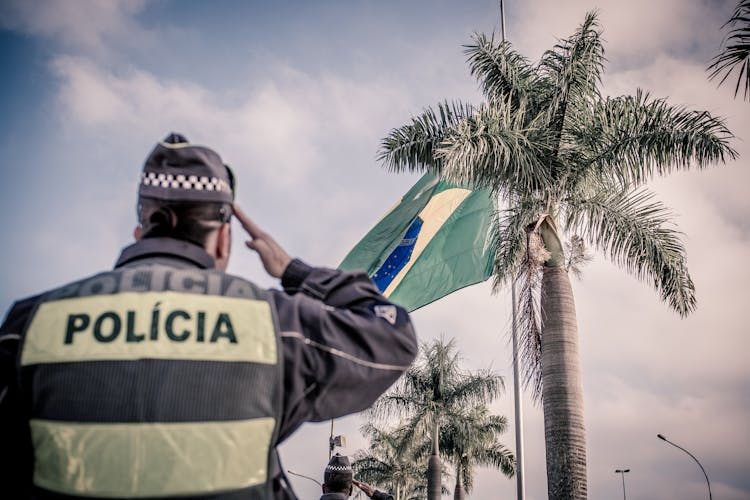 Back View Of A Police Officer Saluting