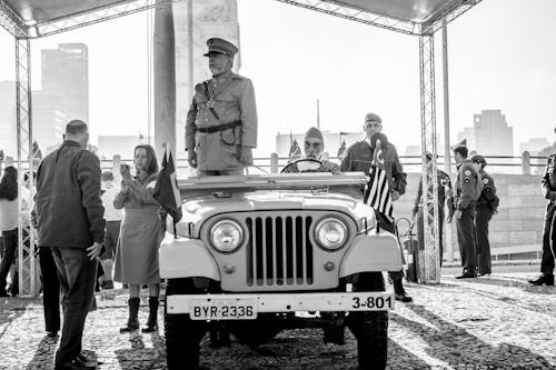 A Military Officer Standing on a Jeep