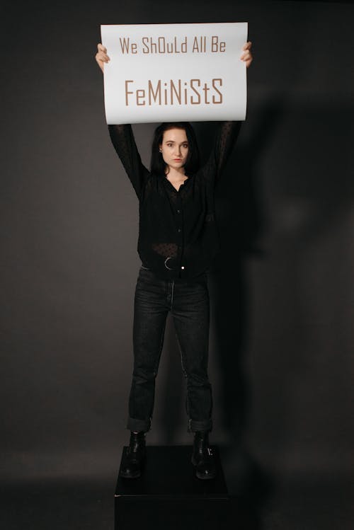 A Woman Raising Her Hands while Holding a Poster