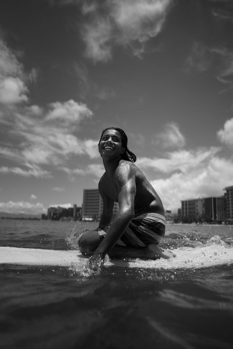 Black Man In Swimwear Surfing In Water