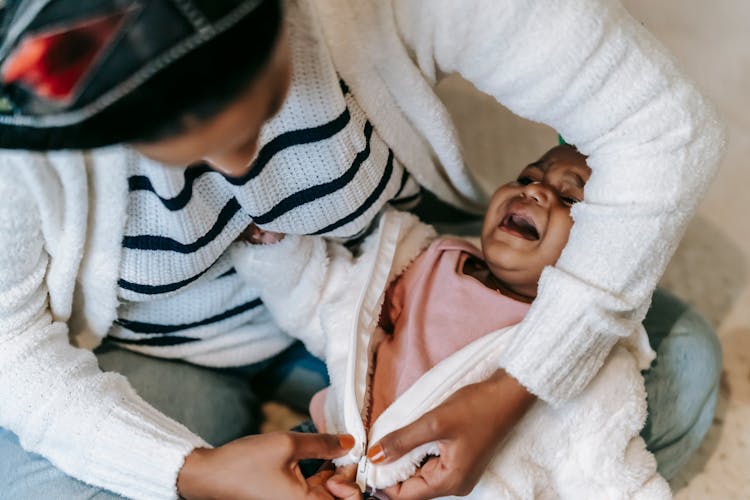 A Mother Changing Her Baby's Clothes