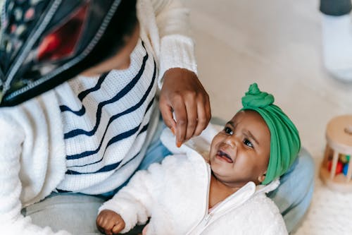 Anonymous ethnic mother embracing crying baby