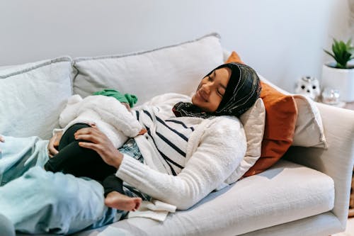 Positive black woman breastfeeding little child