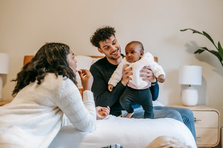 Happy Father And Black Mother Playing With Baby