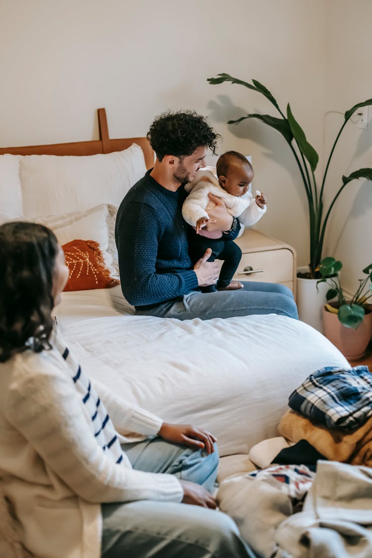 Diverse Family With Newborn Baby In Bedroom