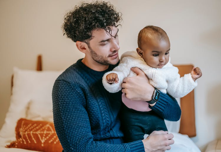 Ethnic Father Cuddling Black Newborn Baby