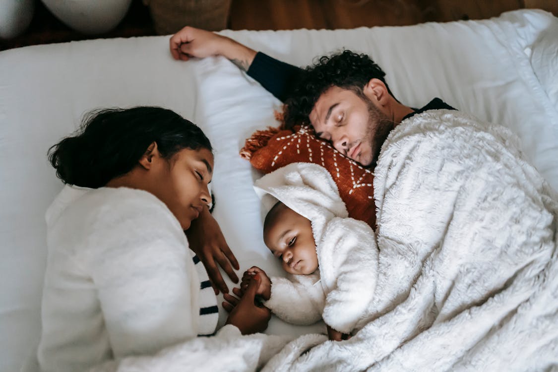 Tranquil multiethnic family sleeping on bed in morning