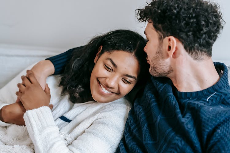 Smiling Loving Multiethnic Couple Cuddling On Couch