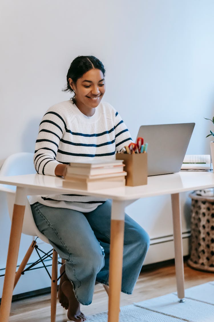 Indian Lady Working Remotely On Laptop At Table In Room