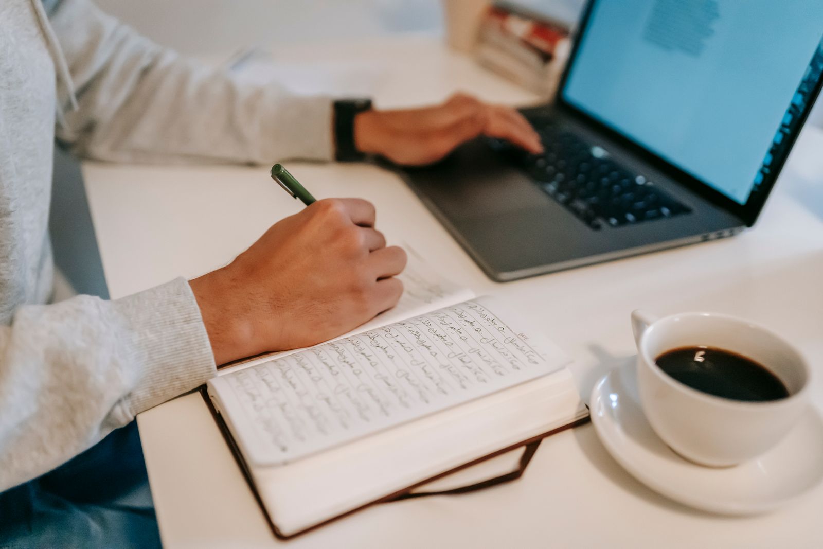 Créateur de contenu travaillant sur ordinateur tout en prenant des notes