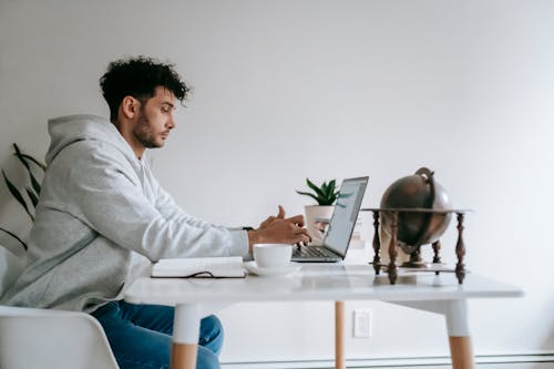 Mężczyzna W Szarej Koszuli Za Pomocą Macbooka Pro