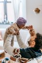 Cheerful multiracial parents playing with cute girl at home