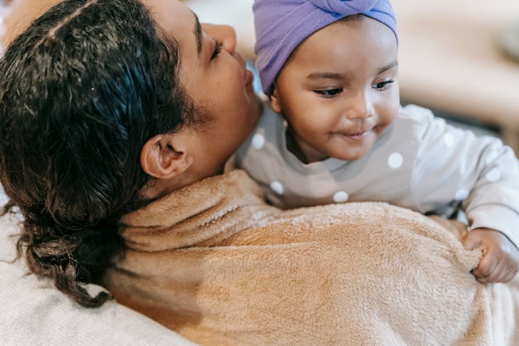 Crop Black Mother Talking To Smiling Little Daughter