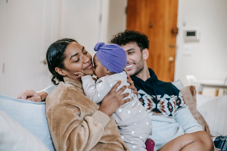 Smiling Multiracial Parents With Cute Little Girl In Living Room