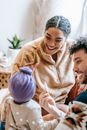 Crop happy multiracial family speaking with anonymous daughter in house