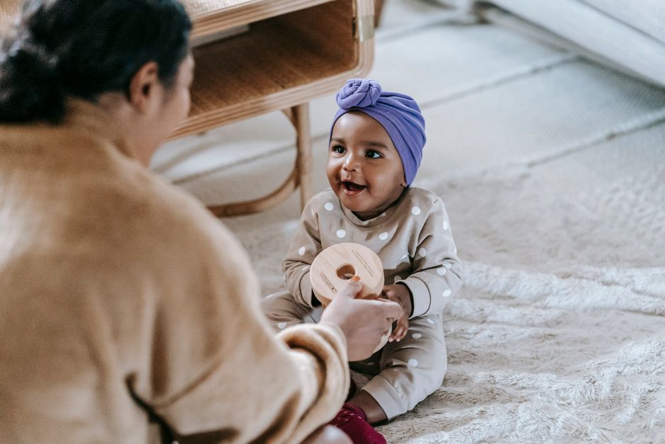 Mãe feliz e bebê brincando juntos em casa