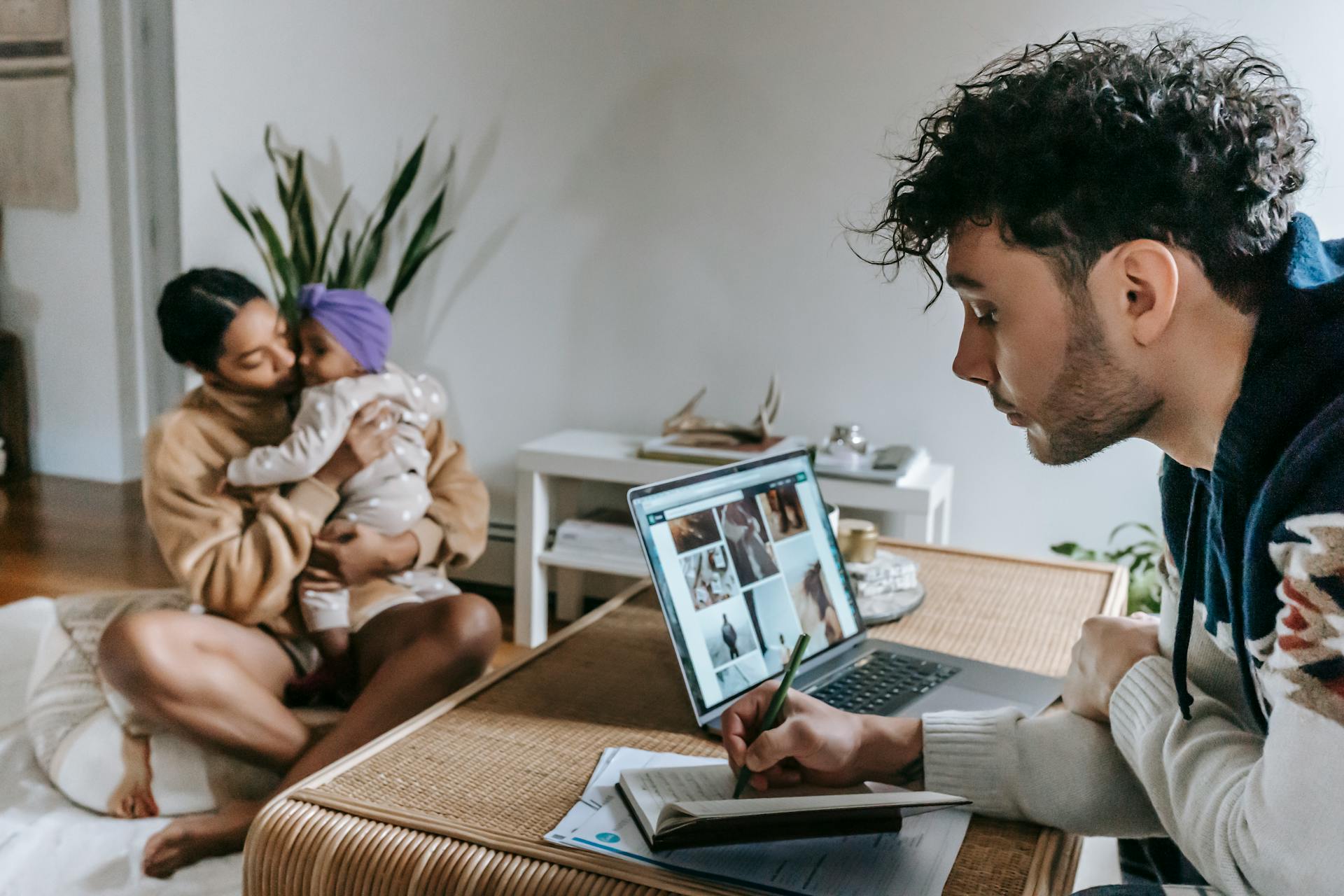 A family enjoying time together at home with a laptop displaying creative work.