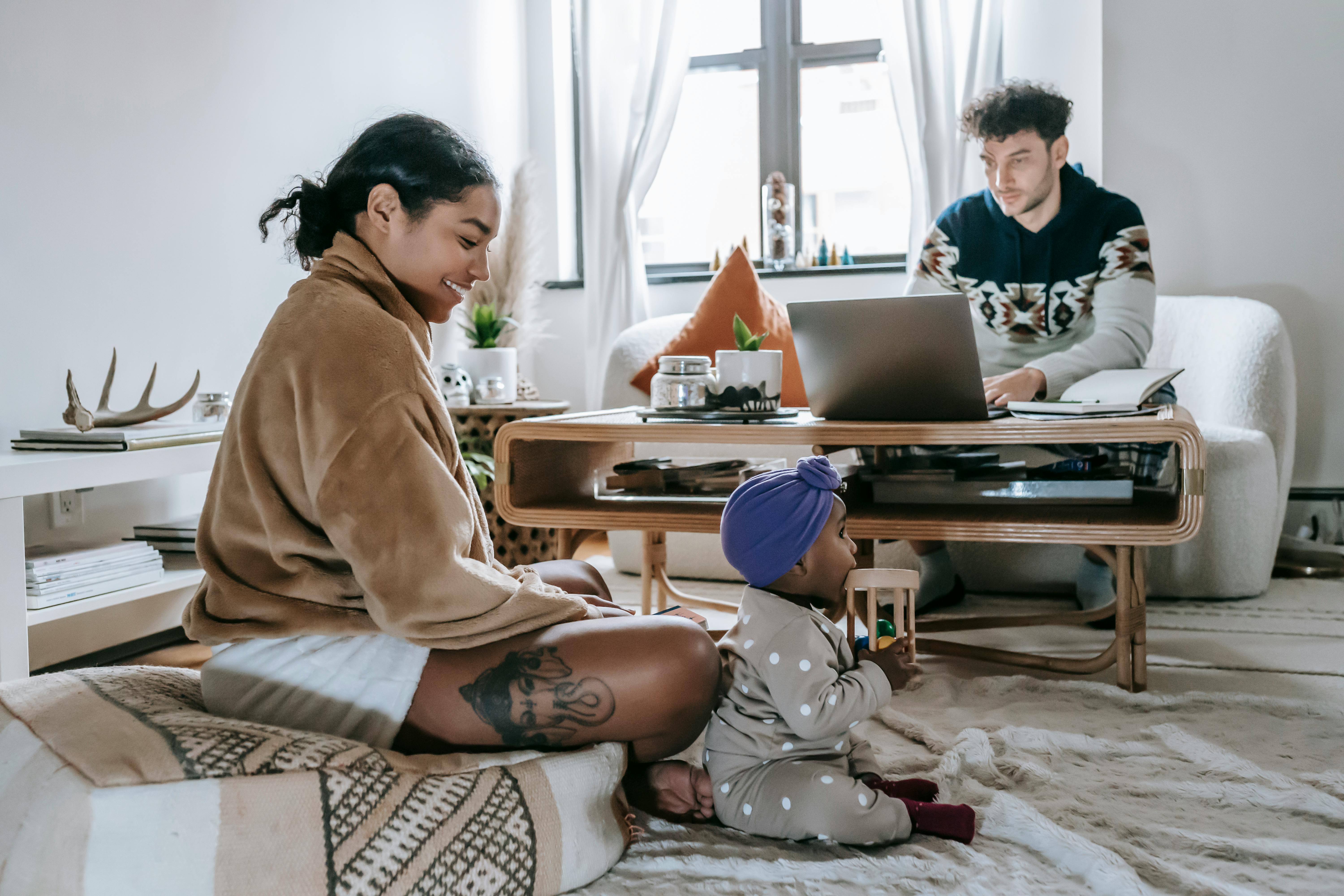 diverse family with black baby spending time at home with netbook