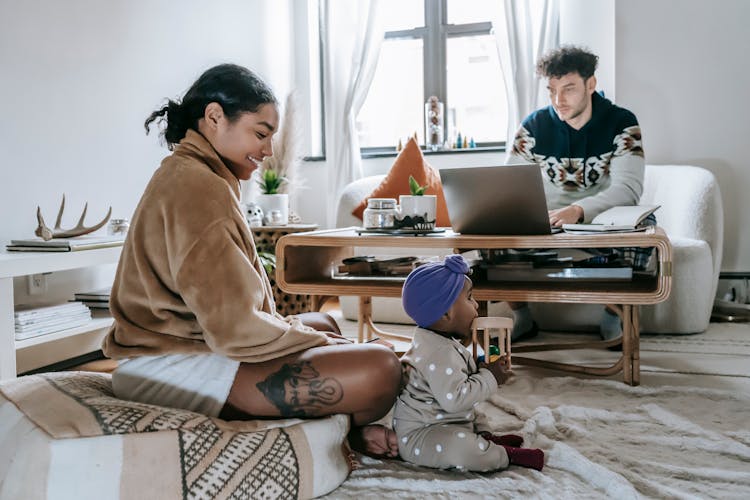 Diverse Family With Black Baby Spending Time At Home With Netbook