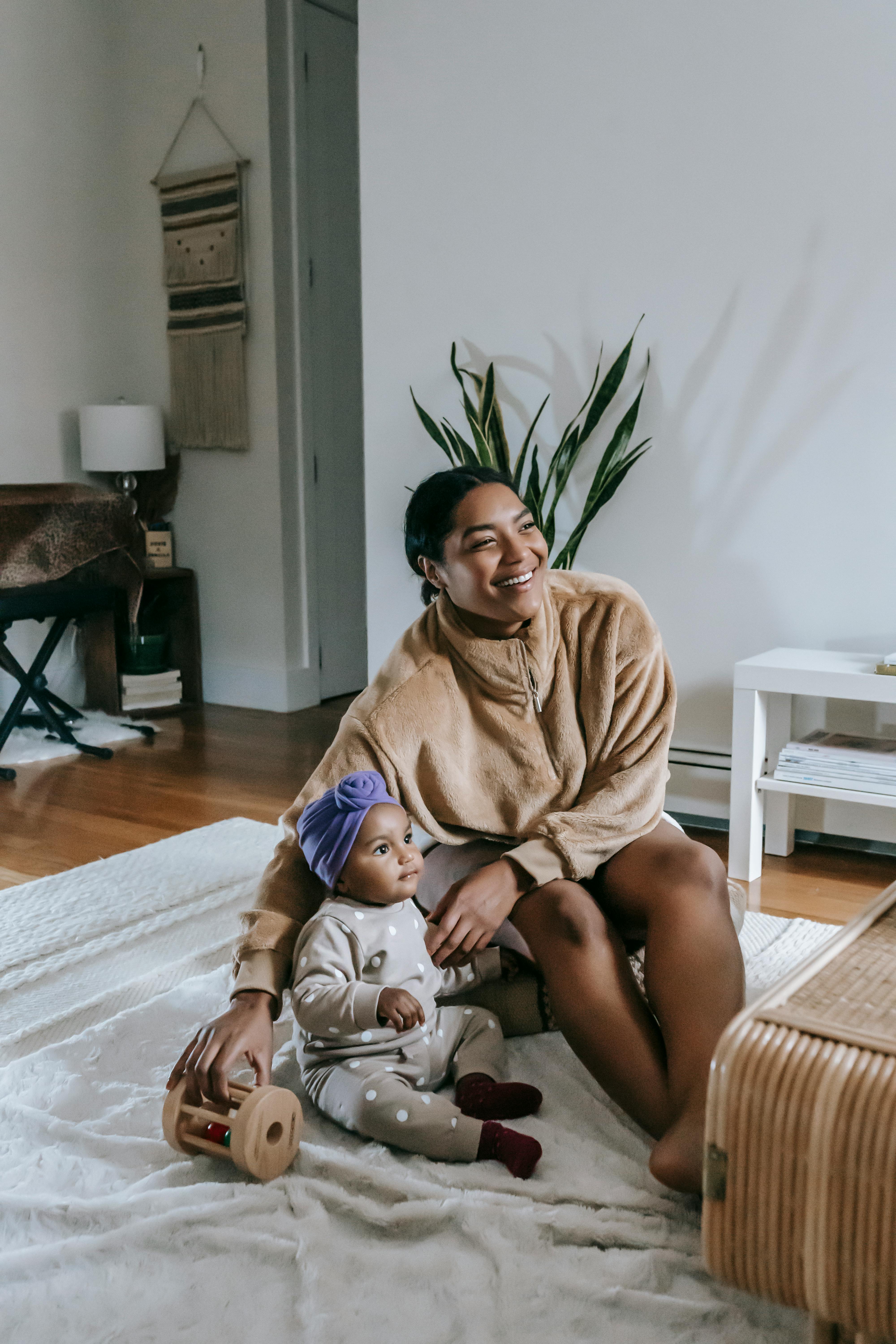 happy mother and baby sitting on the floor