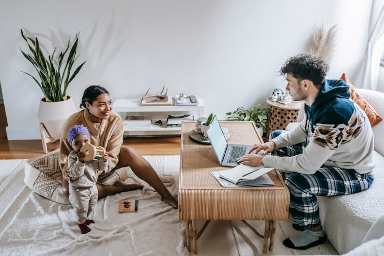 Diverse Family With Little Baby And Modern Laptop