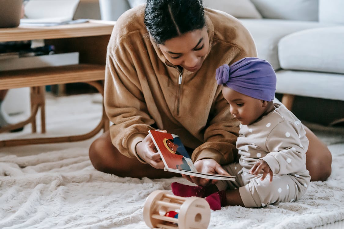Free Mother and Baby Girl Reading a Book Stock Photo
