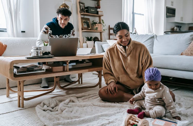 Diverse Family With Little Baby In Room With Netbook