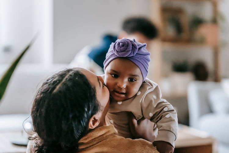 Loving Black Mother Kissing African American Baby In Headwear