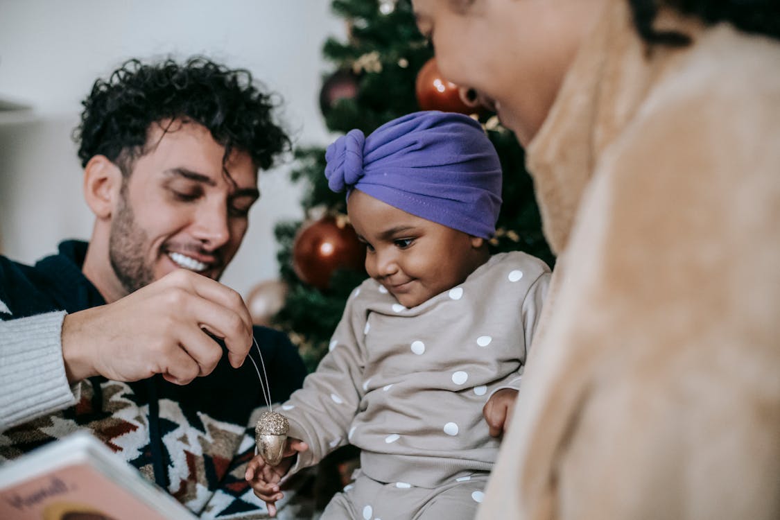 Diverse father and mother playing with little daughter