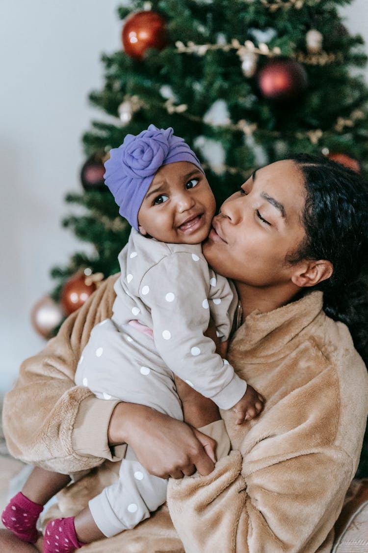 Happy Ethnic Mother Kissing Cute Daughter