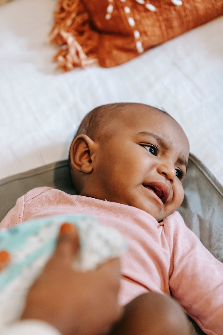 Woman Changing Diaper For Little Black Baby