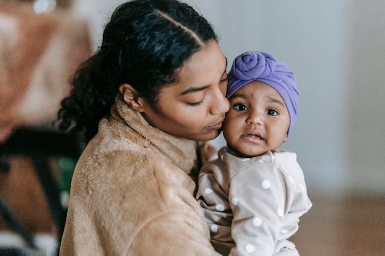 Gentle Black Mother Kissing Cheek Of Adorable Baby