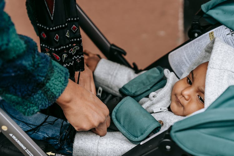 Ethnic Baby Lying On Stroller In Daytime