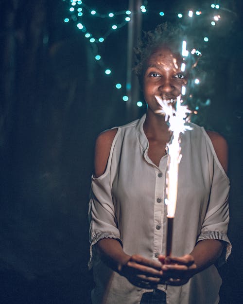 A Woman in White Shirt Holding a Burning Sparkler