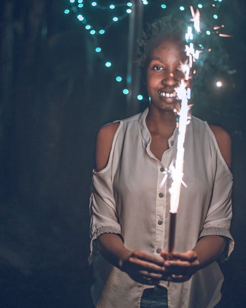 A Smiling Woman Holding a Sparkler