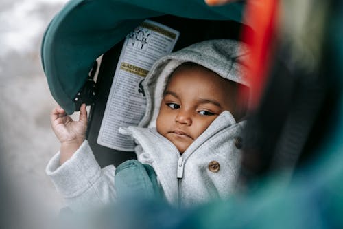 Free Little ethic baby in hood in stroller Stock Photo